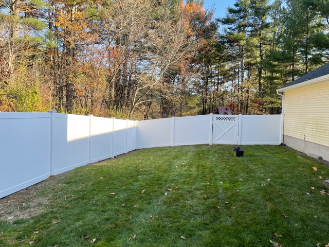Granite State Fence installed 6’ white vinyl privacy fencing with lattice top gates for this yard in Litchfield, NH.