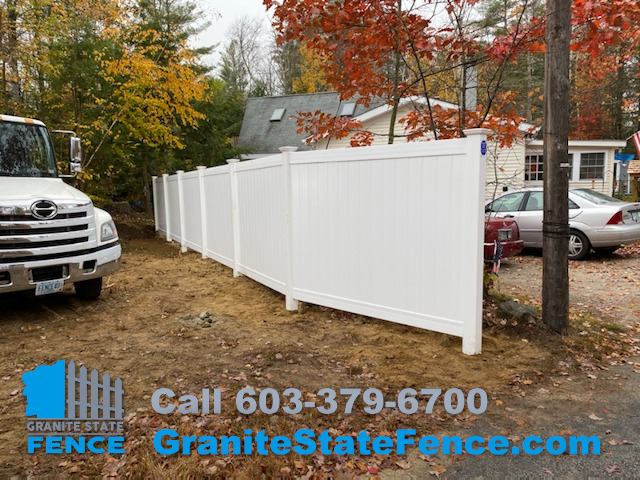 White Vinyl Privacy Fence installed between properties in Raymond, NH.